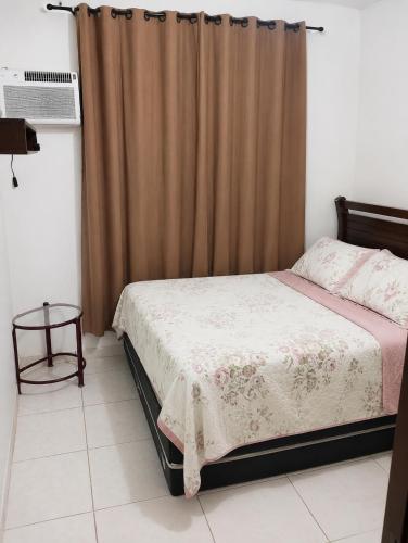 a bedroom with a bed and a brown curtain at Balcony house in Campo Grande