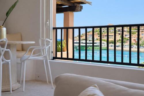 a living room with a balcony with a view of a pool at LUX-Porto Cervo Center Sea View Apartment in Porto Cervo