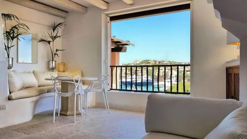 a living room with a table and a large window at LUX-Porto Cervo Center Sea View Apartment in Porto Cervo