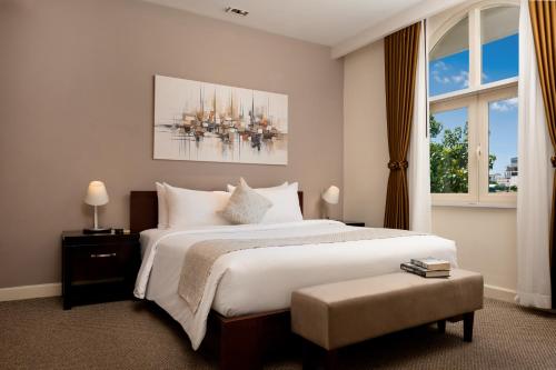 a bedroom with a large bed and a large window at Central Mansions Hotel and Apartments in Phnom Penh