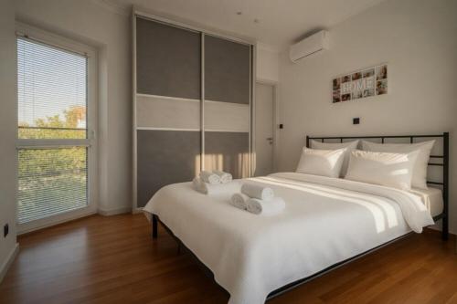 a bedroom with a large white bed with stuffed animals on it at Voula Asklipeio Residence Supreme in Athens
