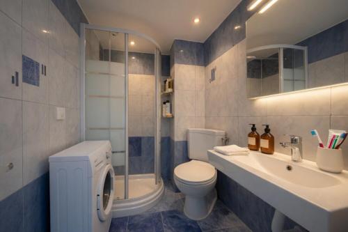 a bathroom with a toilet and a sink and a shower at Voula Asklipeio Residence Supreme in Athens