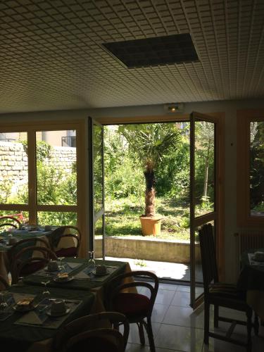 a dining room with a table and chairs and a window at Hotel Couleurs Sud Centre-ville Gare Charleville-Mézières in Charleville-Mézières