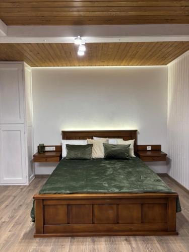 a bedroom with a large bed with a wooden headboard at Pletey house in Verkhovyna