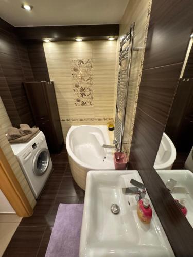 a bathroom with a sink and a tub and a toilet at Apartament Górnicza in Gdynia