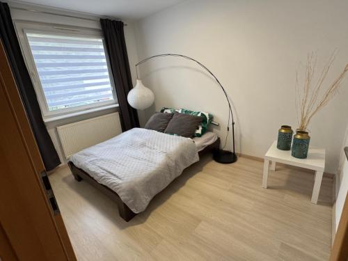 a small bedroom with a bed and a window at Apartament Górnicza in Gdynia