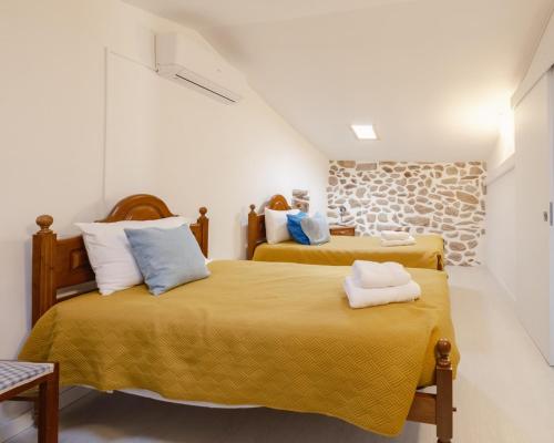 a bedroom with two beds with yellow sheets at Casa da Caleira in Fonte Arcada