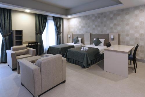 a hotel room with two beds and a table and chairs at Sen Otel in Sakarya
