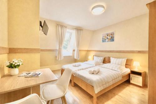 a bedroom with a bed and a table and chairs at Castle Park Suites in Hermina-major