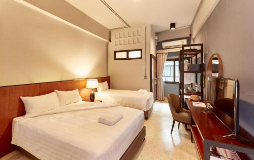a hotel room with two beds and a television at W22 by Burasari in Bangkok