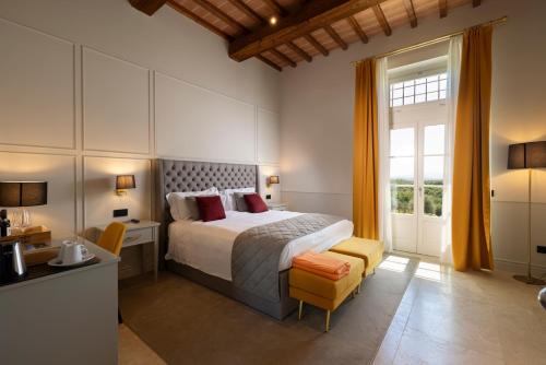 a bedroom with a bed and a desk and a window at Relais Villa Grazianella | UNA Esperienze in Acquaviva