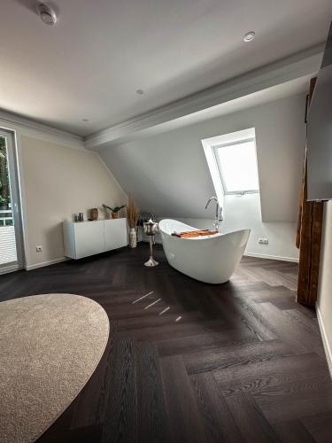 a large bathroom with a tub and a window at LUMEA Devin in Stralsund