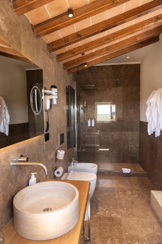 a large bathroom with two sinks and a toilet at Relais Villa Grazianella | UNA Esperienze in Acquaviva