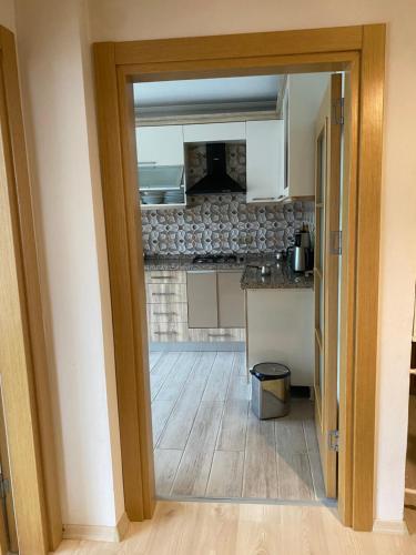 a kitchen with white cabinets and a wooden floor at Komilo Homes - Functional Modern Suite in Çamlıhemşin