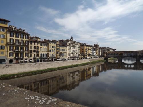 a river in a city with buildings and a bridge at Hotel Berchielli in Florence
