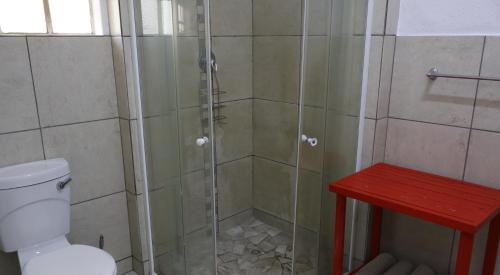 a shower with a glass door in a bathroom at Numbi Hills Self-Catering in Hazyview