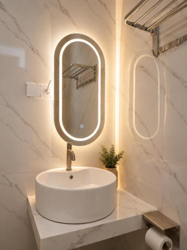 a bathroom with a white sink and a mirror at Bali Queen Cottage in Pabean Buleleng