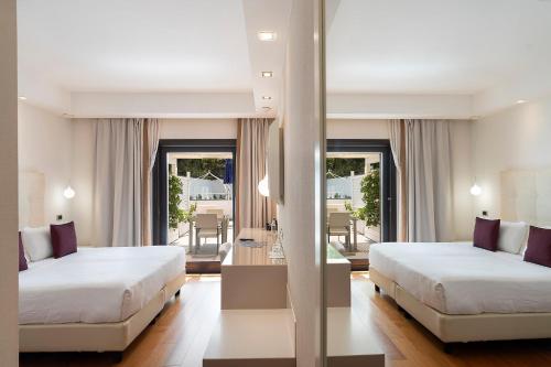 a hotel room with two beds and a mirror at Relais Paradiso in Vietri sul Mare