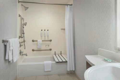 a white bathroom with a tub and a sink at SpringHill Suites by Marriott Buffalo Airport in Williamsville