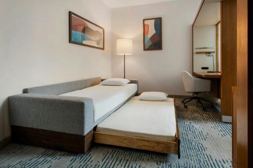 a hotel room with two beds and a desk at SpringHill Suites by Marriott Buffalo Airport in Williamsville