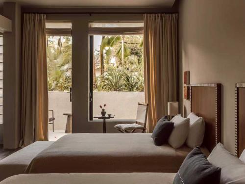 a bedroom with two beds and a large window at is.land Villa in Sanya