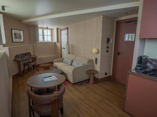 a living room with a couch and a table at Maison Atalaye - Hôtel entièrement rénové in Biarritz