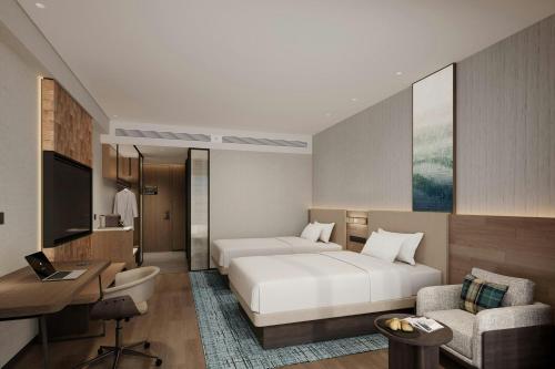 a hotel room with a bed and a desk and a couch at Fairfield by Marriott Kunming Xishan in Kunming