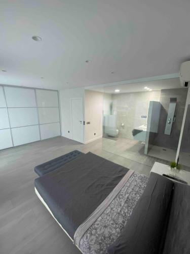 a bedroom with a large bed and a bathroom at Entire 250m2 chalet in Puzol