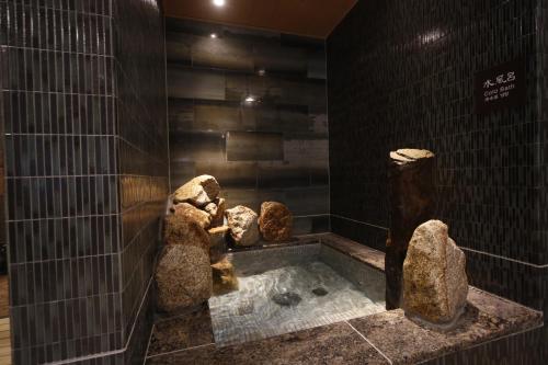 a bath tub with three teddy bears in a room at Dormy Inn Kochi in Kochi