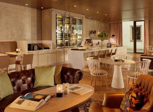 ein Restaurant mit Sofas und Tischen und eine Bar in der Unterkunft Hyperion Hotel Dresden Am Schloss in Dresden