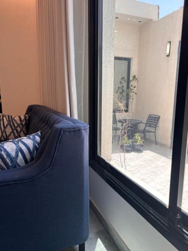 a blue couch sitting in front of a window at وحده خاصة بمدخل مباشر s1 in Al Kharj