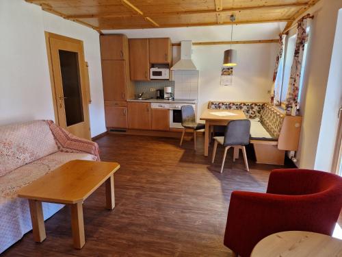a living room with a couch and a table at Gästehaus WOLFGARTEN in Sankt Jakob in Defereggen