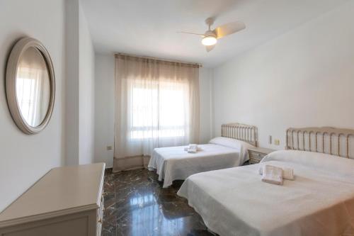 a hotel room with two beds and a mirror at house las chuchas CALAHONDA in Motril
