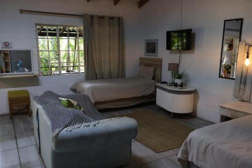 a bedroom with two beds and a couch in a room at Numbi Hills Self-Catering in Hazyview