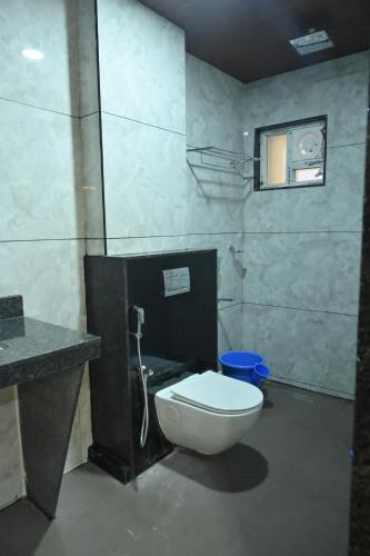 a bathroom with a white toilet and a sink at Kamath Yatri Nivas Plus in Māvalli