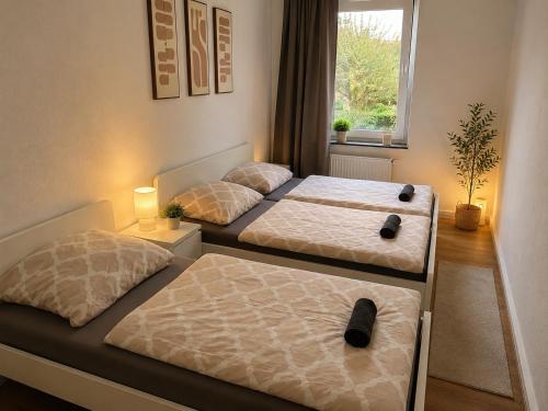 two beds in a room with a window at Central Rooms Hauptbahnhof Koblenz in Koblenz