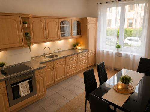 a kitchen with wooden cabinets and a dining table at Central Rooms Hauptbahnhof Koblenz in Koblenz