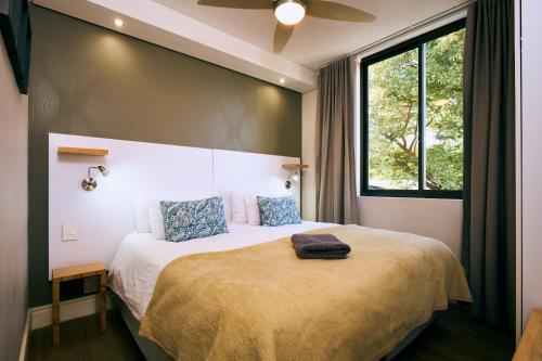 a bedroom with a large bed with a large window at iKON Apartments in Windhoek