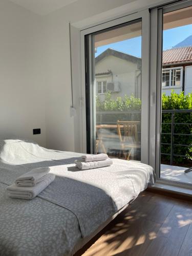 a bedroom with a bed and a large window at Casa Mare in Prčanj