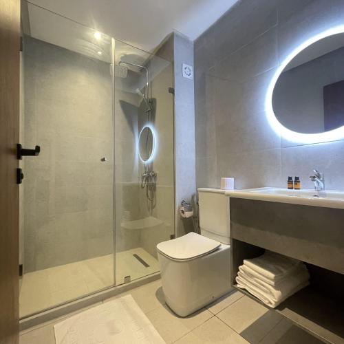a bathroom with a shower and a toilet and a sink at L'escale Appart-hôtel By 7AV HOTELS in M'diq