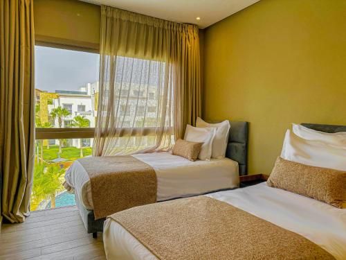 a hotel room with two beds and a window at Dominium Residence in Agadir