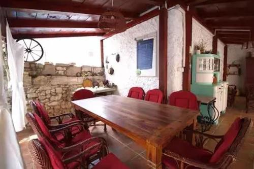 a dining room with a wooden table and red chairs at Charming Villa in Jezera with Private Pool in Jezera