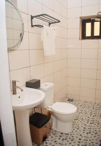 a bathroom with a toilet and a sink at Hotel St Flavien Lomé in Taméklo