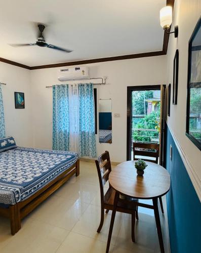 a bedroom with a bed and a table and a table sidx sidx at Turtlenest by the Beach in Morjim
