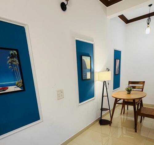 a room with blue and white walls and a table at Turtlenest by the Beach in Morjim