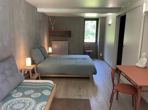 a bedroom with a bed and a desk and a couch at Le Moulin de St André in Saint-André-en-Morvan