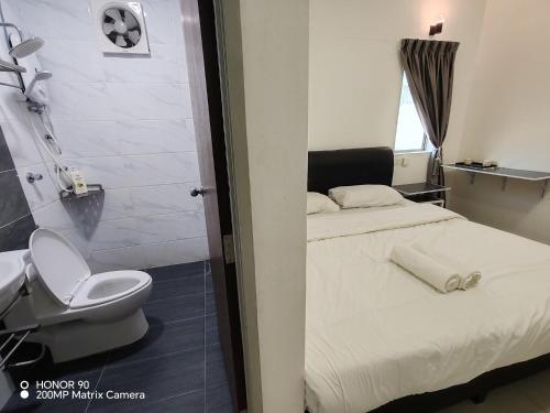 a bedroom with a bed and a toilet and a shower at Arkid 10 Guesthouse in Ipoh