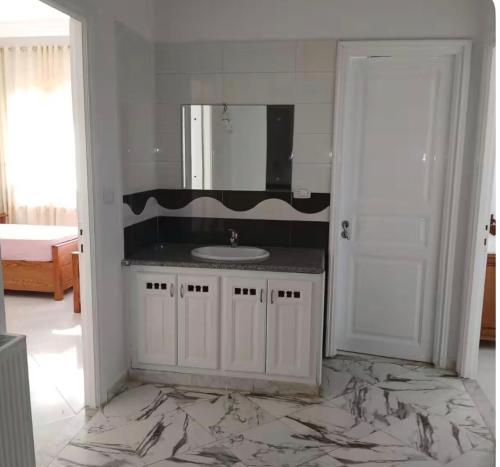 a bathroom with a sink and a mirror at Villa Korba 1st Floor in Korba