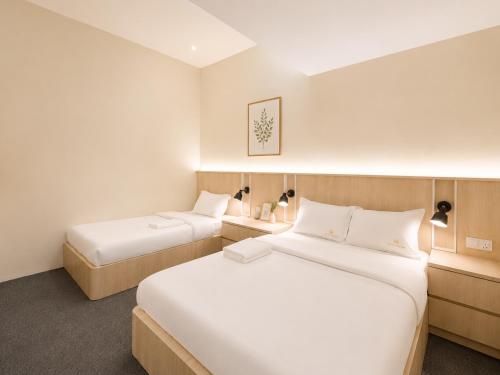 a hotel room with two beds and two lamps at Commune Lane Guesthouse, George Town in George Town
