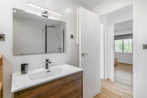 a white bathroom with a sink and a mirror at Casa di soza in Busot